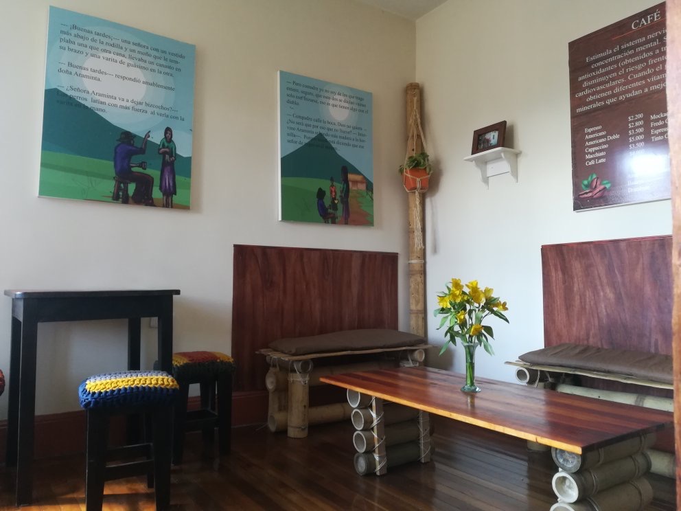 Interior de Veloo Chocolate Café y Maíz con bancos de bambú y murales ilustrados